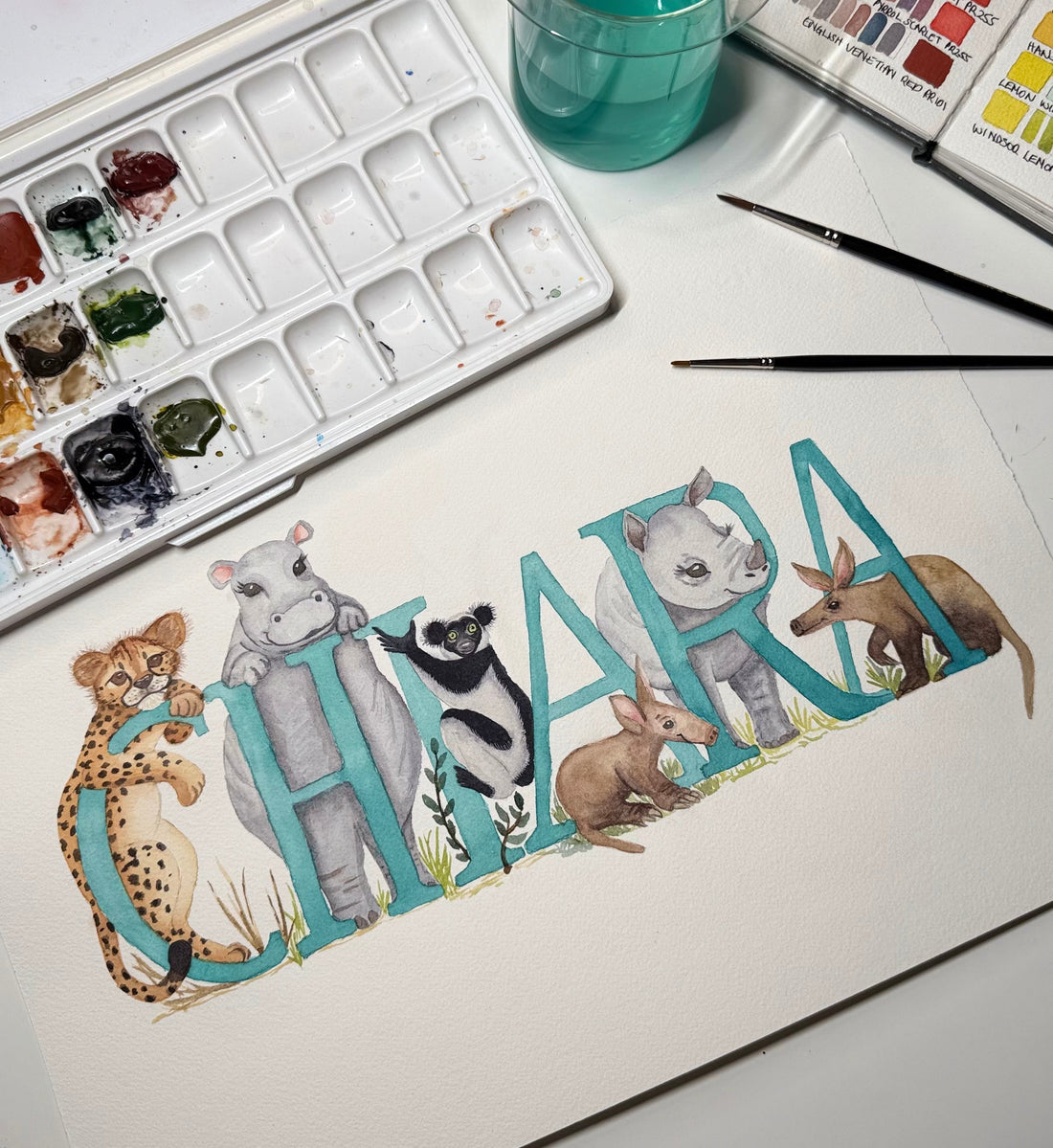 Personalised watercolour name painting spelling Chiara with hand-illustrated wildlife animals for nursery wall art
