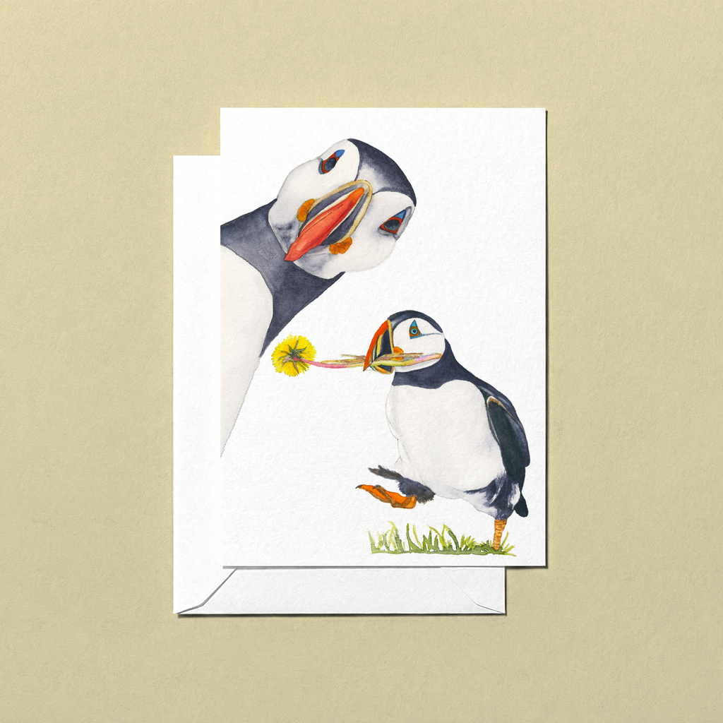 Greeting card with two puffins on a beige background