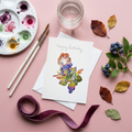 Greeting card with a mouse among berries watercolour illustration on a pink surface with art supplies and decorative elements.