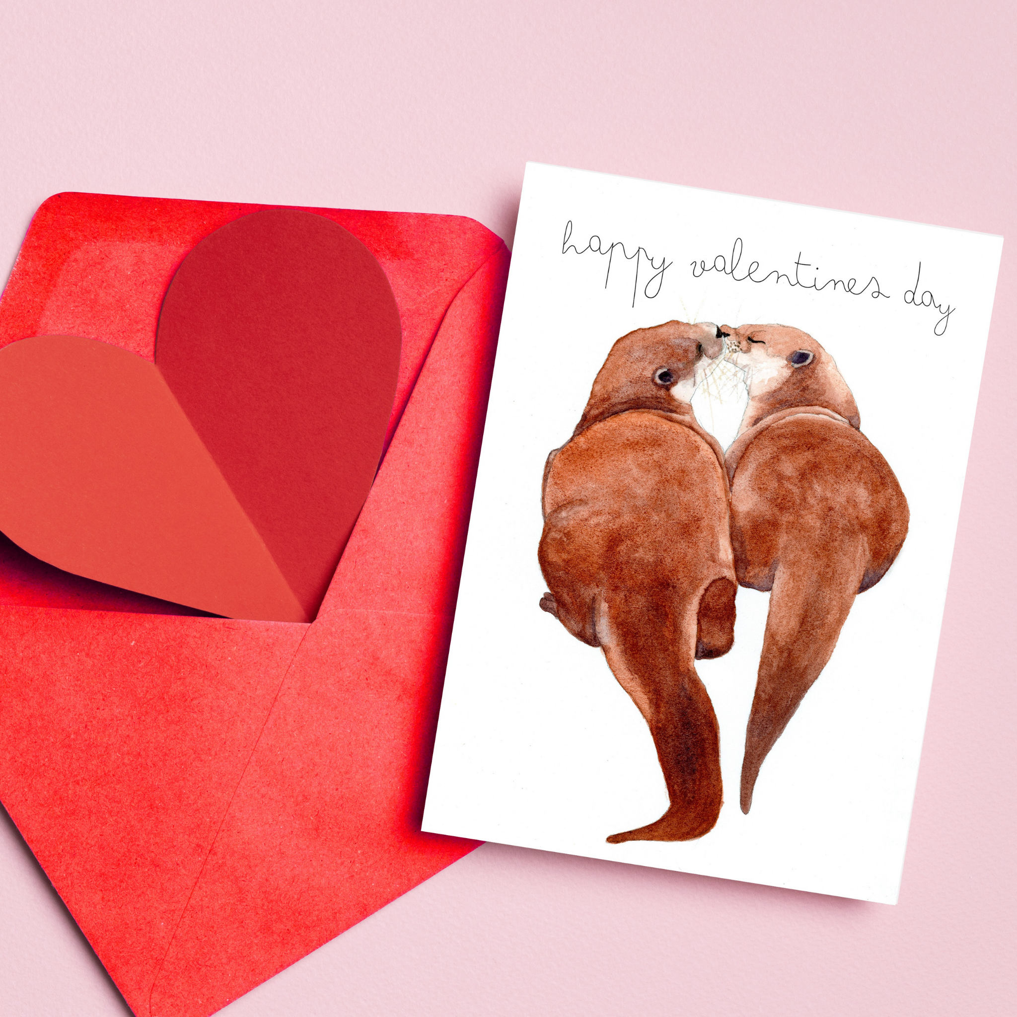 Valentine's Day card with two otters and a red heart-shaped envelope on a pink background