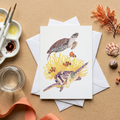 Greeting card with turtle watercolour illustration on a beige surface with art supplies